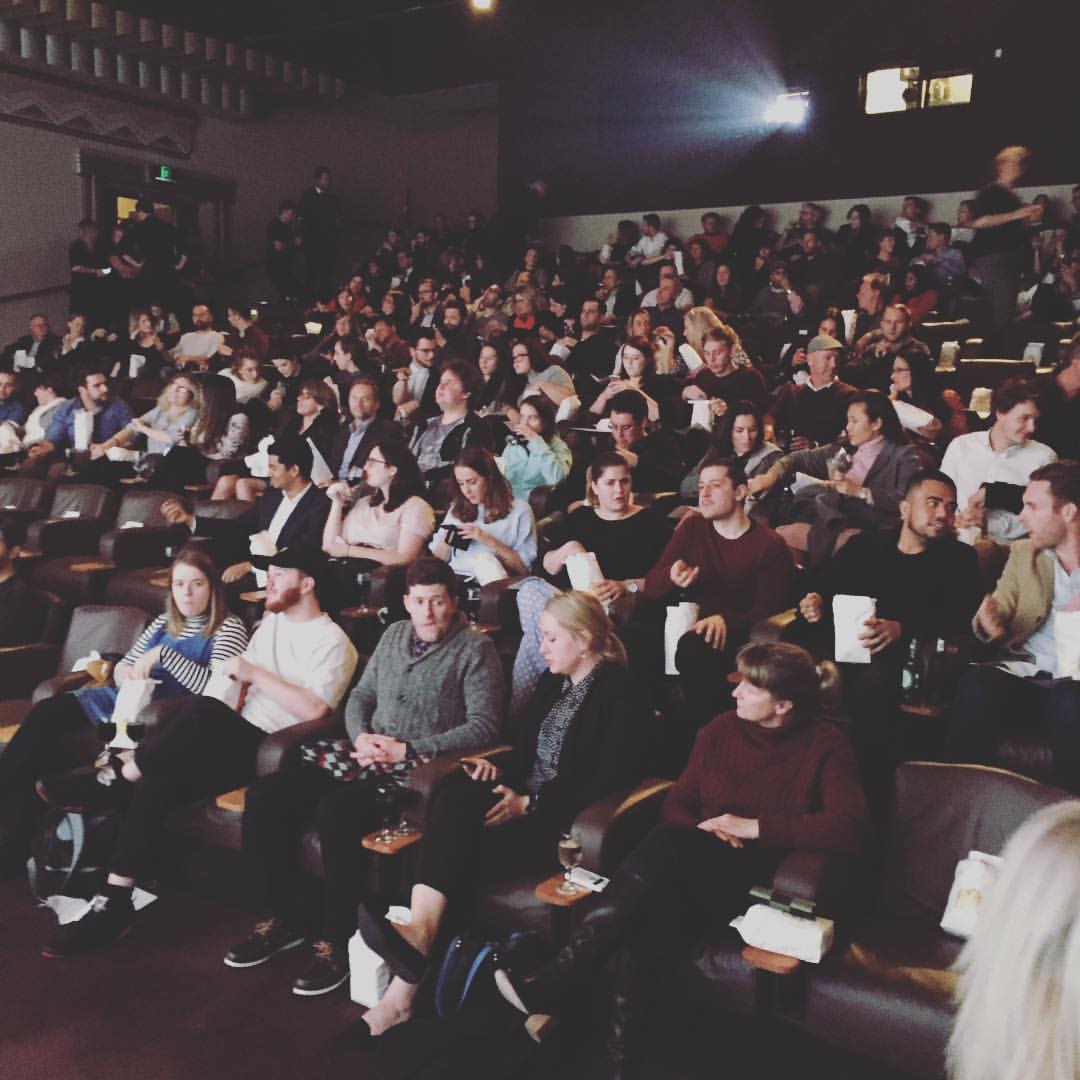 people sitting in setting sun film festival theatre